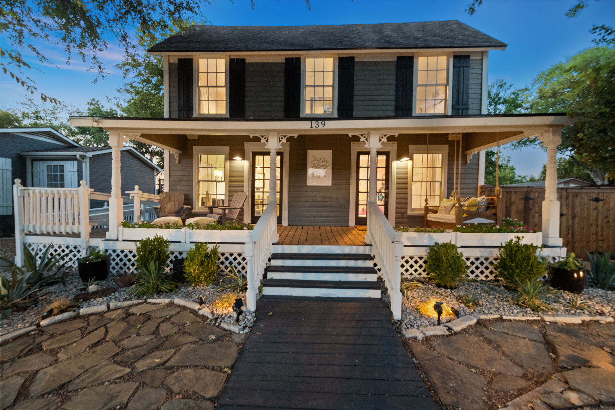 139 Olive’s exterior at dusk, with a covered porch and illuminated windows.
